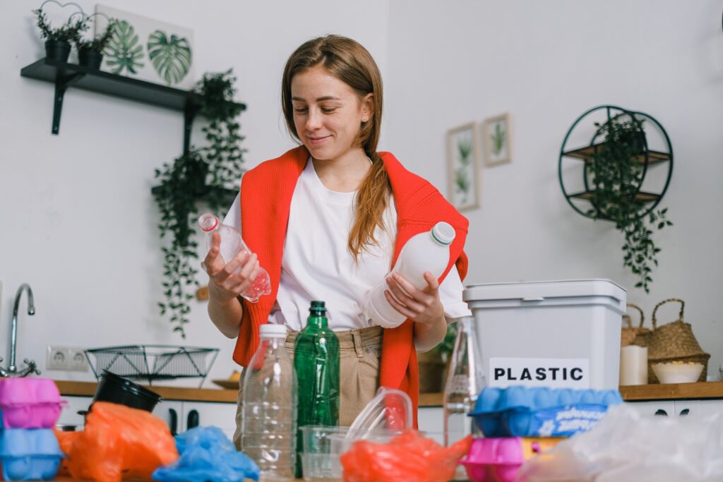 A woman is recycling plastic bottles